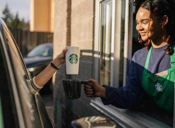 ordering with perso<em></em>nal starbucks cup at the drive-thru