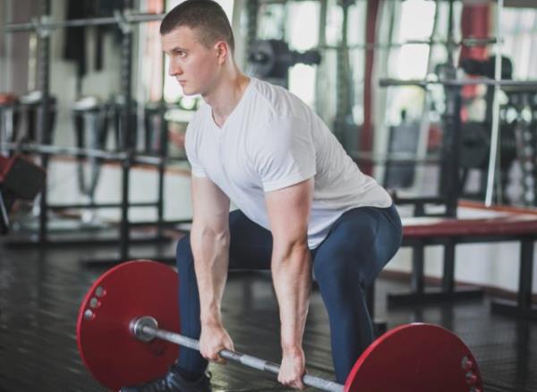 fit man doing sumo deadlift exercise