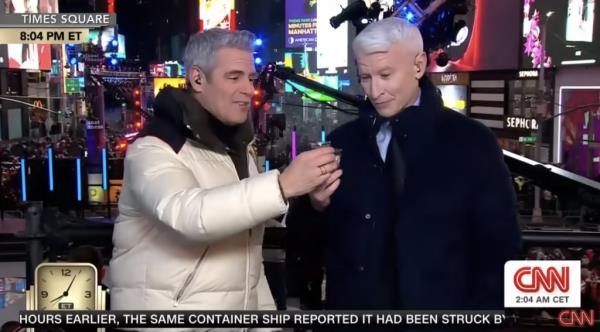 Andy Cohen and Anderson Cooper toast up their shot glasses for the New Year. 