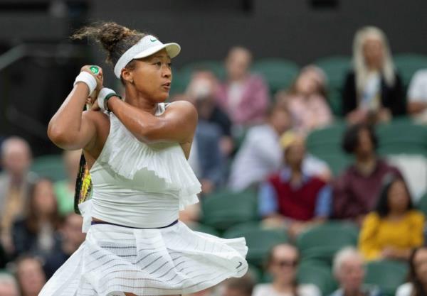 Tennis player strikes ball.