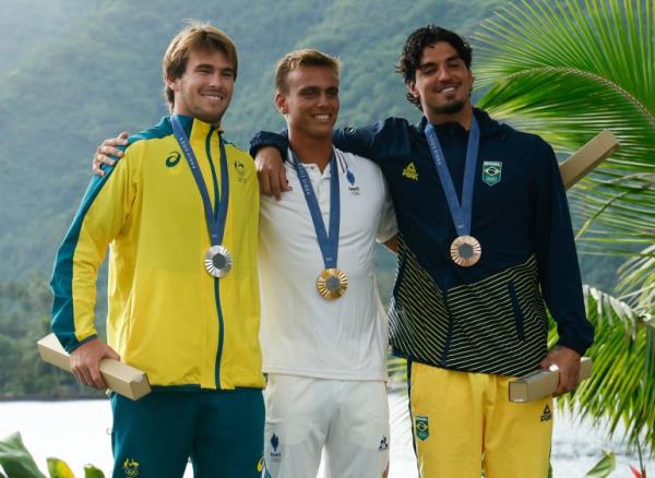 Three surfers receiving Olympic medal.