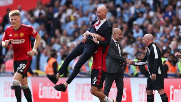 Manchester United's Lisandro Martinez lifts manager Erik ten Hag. Pic: AP