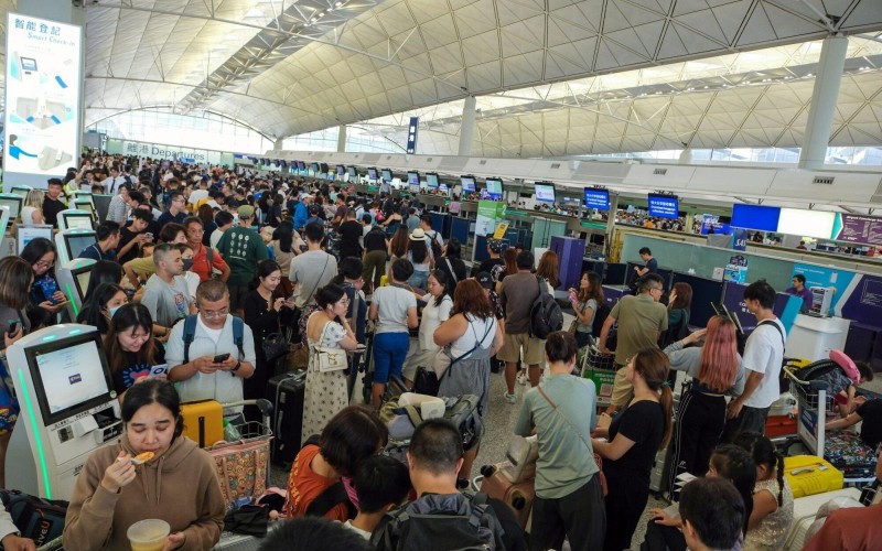 Travelers queue for check-in for Hong Kong Express Airways