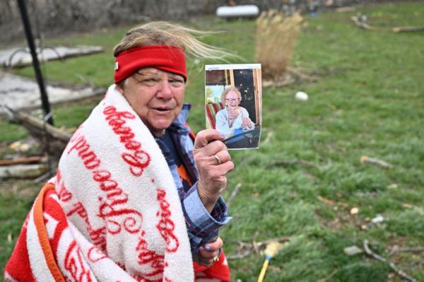 Debbie Carter, a Sullivan resident, displays a photograph she found in a field near her home the day after a tornado hit the area.