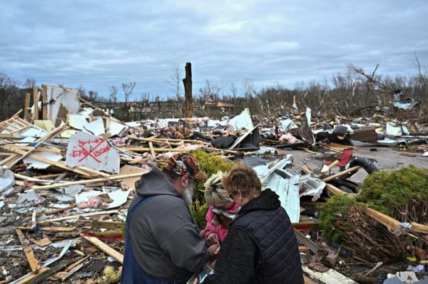 People pray at the sight of their destroyed school.