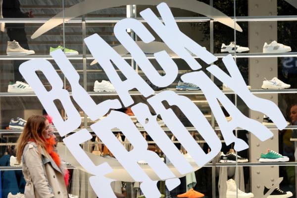 A woman walks past a shop offering Black Friday deals in Manchester, Britain, November 26, 2022.</p>

<p>　　