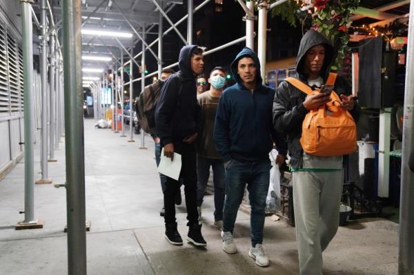 Migrants getting off a school bus that transported them to the NYPD police academy wher<em></em>e they were going to spend the night.