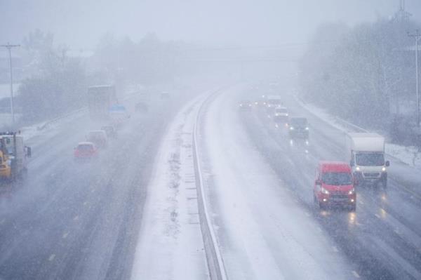 Cars driving through snow on the the M5 motorway near Taunton, England, Wednesday March 8, 2023.