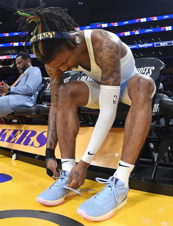 Ja Morant ties his Ja 1 sneakers before a Grizzlies game in April 2023.