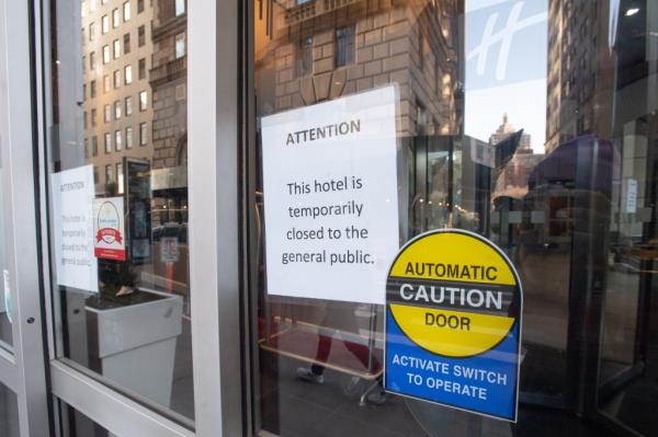 A paper sign affixed to the Holiday Inn window in the Financial District says that it is closed to the public. 