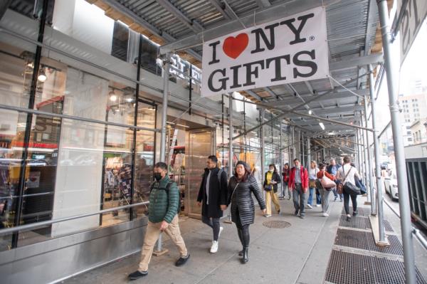 Pedestrian walk past the souvenir store I [Love] NY Gifts near Times Square.