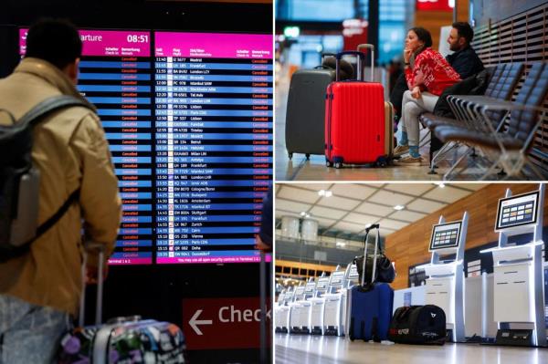 Passengers look at departure panels showing canceled flights during a general strike by employees over pay demands, at the Berlin Brandenburg Airport (BER), in Schoenefeld near Berlin on Jan. 25, 2023.