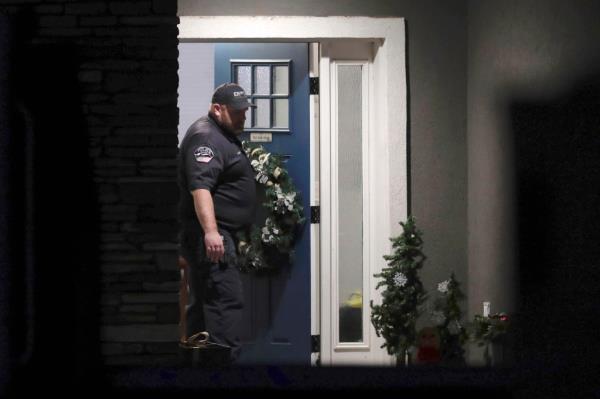 A law enforcement official stands at the front door of the Haight family's home.