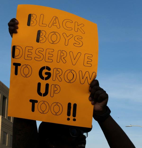 Protester holding sign that reads, 