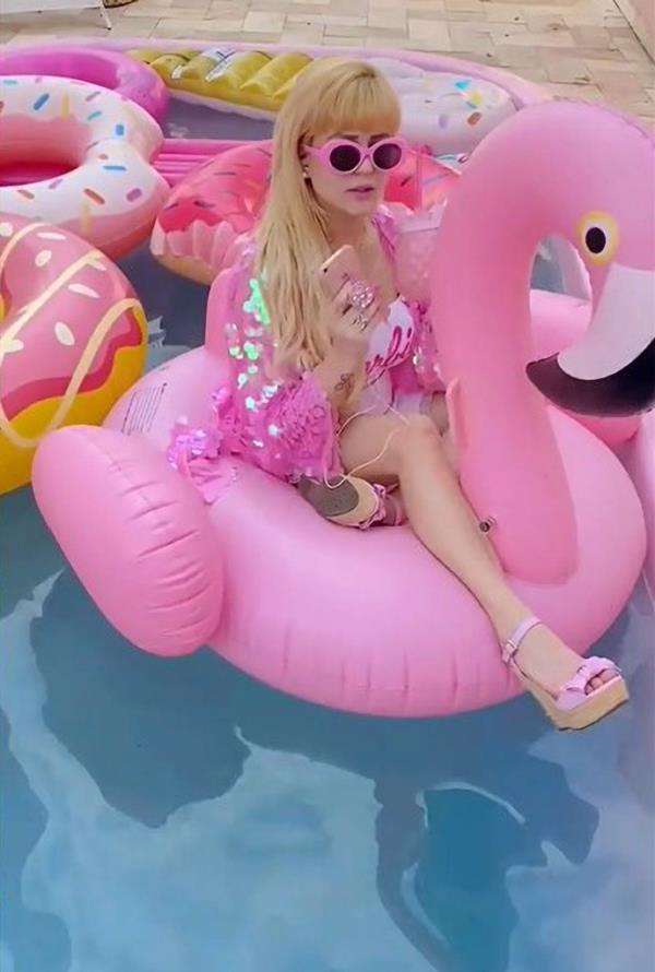 Peres in a pool on a pink flamingo floaty