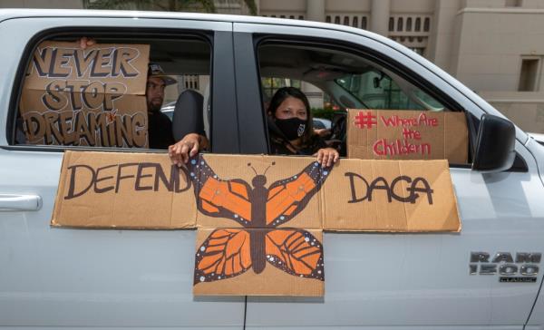 DACA advocates hold a sign supporting the program