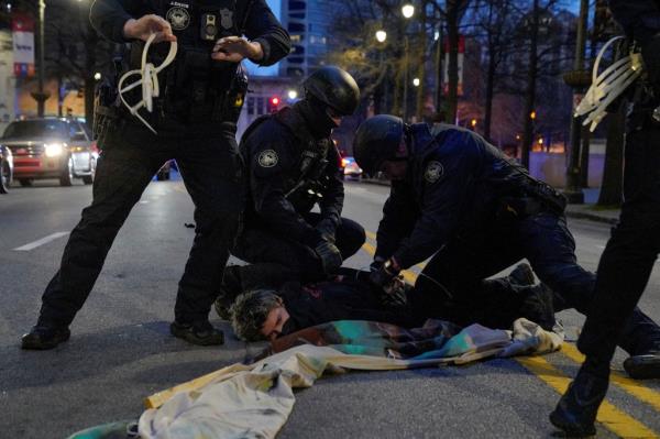 A protester is detained during Saturday's demo<em></em>nstrations in Atlanta. 