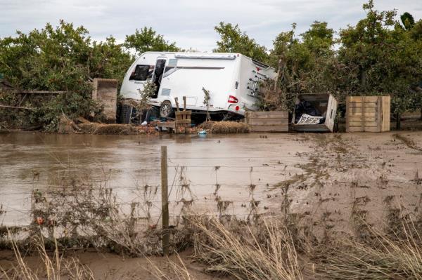 vehicle is piled on debris and surrounded by floodwater in Hawkes Bay, New Zealand, Friday, Feb. 17, 2023.