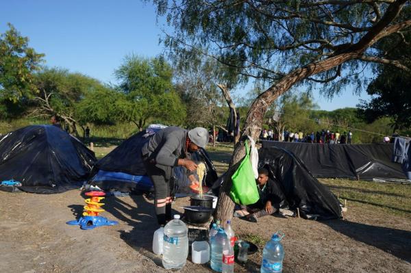 A Venezuelan migrant serves himself a plate of pasta at a makeshift camp in Matamoros, Mexico.