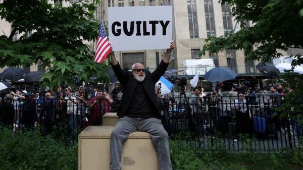 A man holding a placard after Do<em></em>nald Trump was found guilty on all counts in his criminal trial a<em></em>bout covering up hush mo<em></em>ney payments by falsifying business records. Pic: Reuters