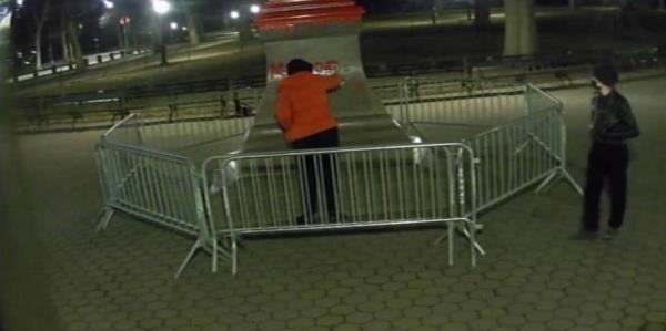 Footage shows one of the vandals spray painting the statue.