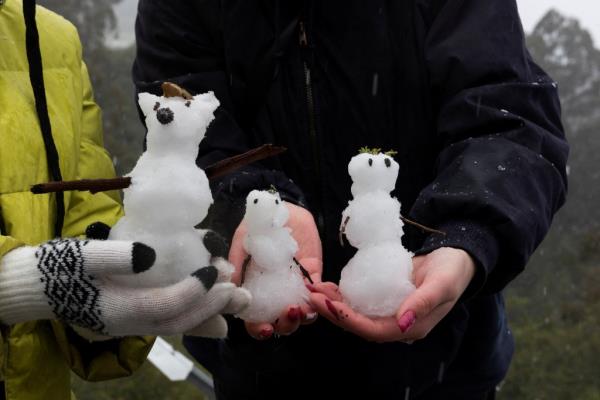 Local residents carry snowmen as snow falls over the hills around the Bay Area while a massive winter storm passes along the west coast, delivering snow, freezing rains, and gusty winds, on Grizzly Peak Boulevard near Oakland, California, U.S., February 24, 2023.