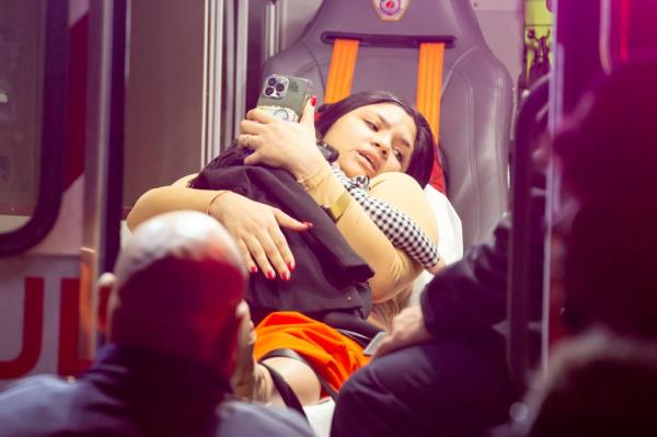 A woman is taken into an ambulance after the Inwood crash, which injured 22 people late Monday.