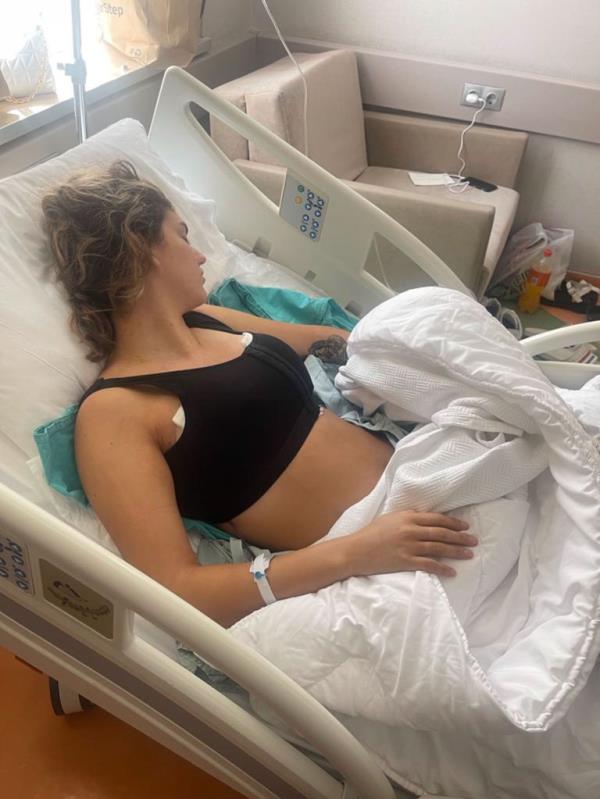 Woman in hospital bed black surgical bra.