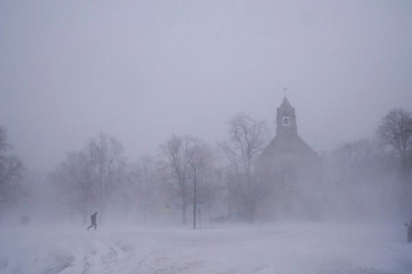 A lone pedestrian in snow shoes makes his way across Colo<em></em>nial Circle as St. John's Grace Episcopal Church rises above the blowing snow amid blizzard co<em></em>nditions in Buffalo, N.Y