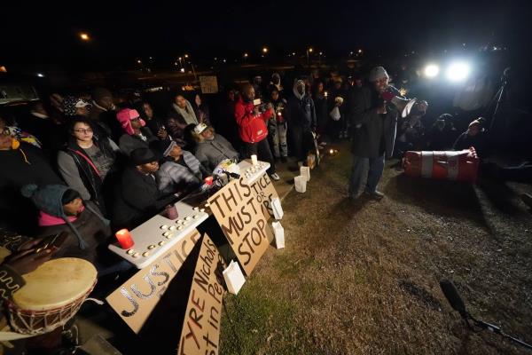 Rev. Andre E Johnson, of the Gifts of Life Ministries, preaches at a candlelight vigil for Tyre Nichols, who died after being beaten by Memphis police officers, in Memphis, Tenn., Thursday, Jan. 26, 2023. Behind him, seated center, are Tyre's mother RowVaughn Wells and his stepfather Rodney Wells. 