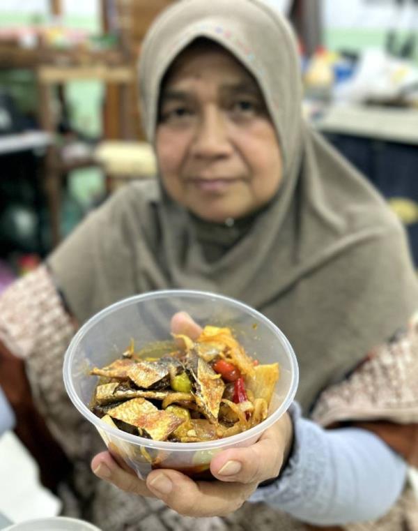  Tengku Hayati Akmal Tengku Hitam, 65, serves her popular salted fish acar into co<em></em>ntainers for sale at the home in Taman Wangi, Gua Musang. The popular dish is a much sought after delicacy during the mo<em></em>nth of Ramadan. - Pic: BERNAMA