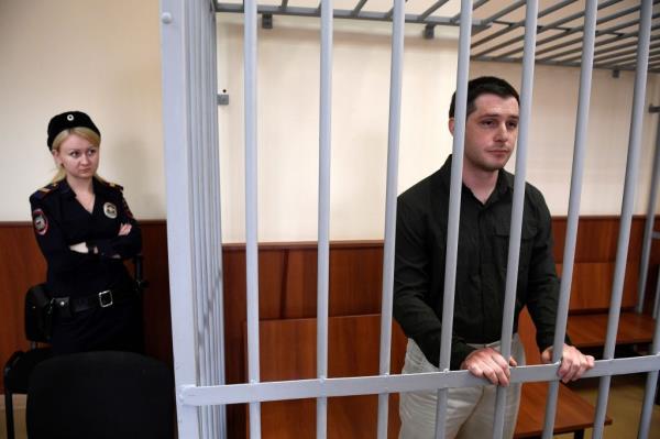 US ex-marine Trevor Reed, charged with attacking police, stands inside a defendants' cage during a court hearing in Moscow on March 11, 2020.