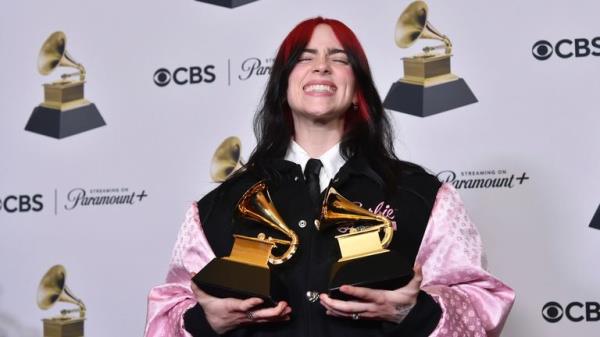 Billie Eilish poses in the press room with the awards for best song written for visual media and song of the year for 