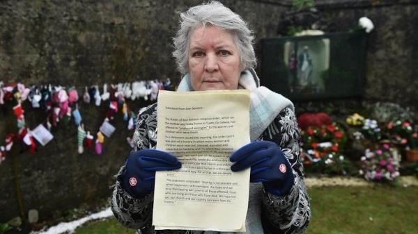 Carmel Larkin holding apology at Tuam site
