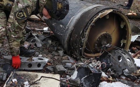 A bomb squad member works next to remains of a missile at the site wher<em></em>e residential buildings were heavily damaged during a Russian missile attack on Kharkiv on Tuesday