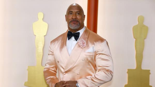 Dwayne Johnson poses on the champagne-colored red carpet during the Oscars arrivals at the 95th Academy Awards in Hollywood, Los Angeles, California, US, March 12, 2023. REUTERS/Eric Gaillard
