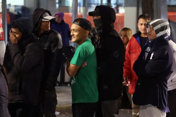 Migrants queue up outside the Chicago police 1st District station on Oct. 30, 2023, to get do<em></em>nated clothing better suited for colder temperatures.  