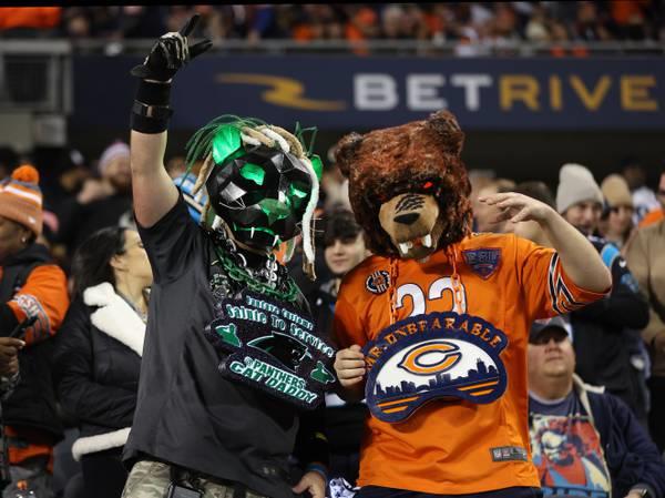 A Panthers fan and a Bears fan pose for a photograph before the start of a game between the two teams at Soldier Field on Nov. 9, 2023.