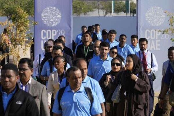 People walk through the venue at the COP28 U.N. Climate Summit on Friday, in Dubai, United Arab Emirates. (Picture: AP Photo/Rafiq Maqbool)