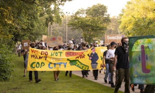 people with signs saying we do not want cop city