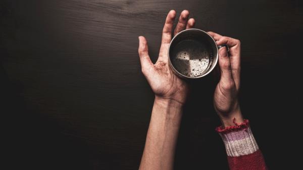 Person holding empty me<em></em>tal cup