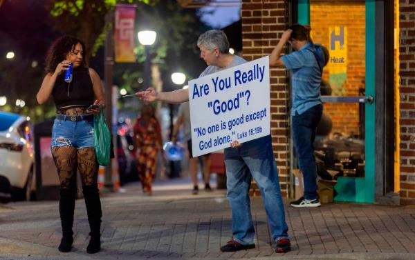 Jeff Duffy from Shiloh Presbyterian Church hands out literature on Glenwood Avenue on Friday July 21, 2023 in Raleigh, N.C. Duffy encourages those passing by to follow Christ and co<em></em>nsider attending services at Shiloh.