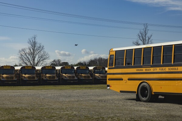 A U.S. fighter jet flies over a Virginia Beach City Public Schools lot near Naval Air Station Oceana, Tuesday, Feb. 6, 2024, in Virginia Beach, Va. (AP Photo/Tom Brenner)
