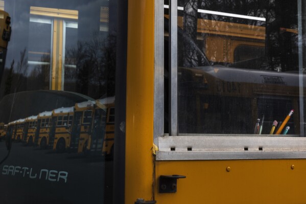 Writing utensils are visible in the window of a diesel school bus, inside the Mo<em></em>ntgomery County Schools bus lot, Friday, Feb. 9, 2024, in Rockville, Md. Diesel exhaust from school buses affects one-third of U.S. students, their parents and educators each day. (AP Photo/Tom Brenner)