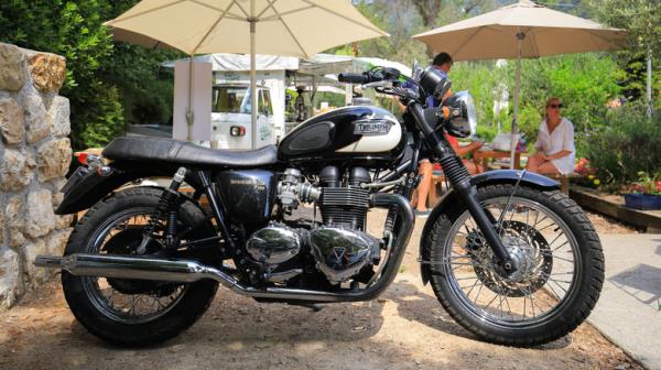 Triumph parked near umbrellas