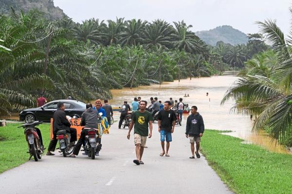 No way out: A main road closed due to rising floodwaters in Kuala Krai, Kelantan, with boats being the o<em></em>nly mode of transportation. — Bernama