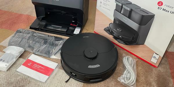 Robotic vacuum on floor next to product packaging