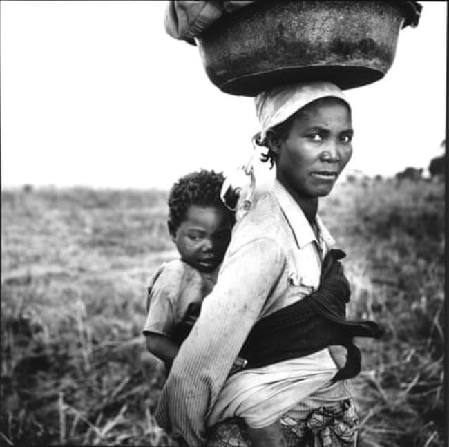 A woman and her child make their way to the refugee camp near Cuemba