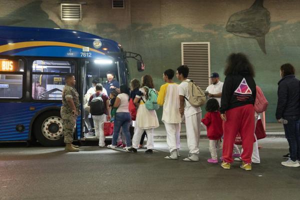 Immigrants leave the Port Authority Bus Terminal on 8th Ave. for a city run processing center on a MTA bus Saturday, May, 13, 2023 in Manhattan.