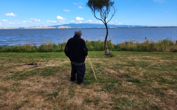 Kaiwhakahaere taiao, Rawiri Smith, looks out over Wairarapa moana from the western side of the lake